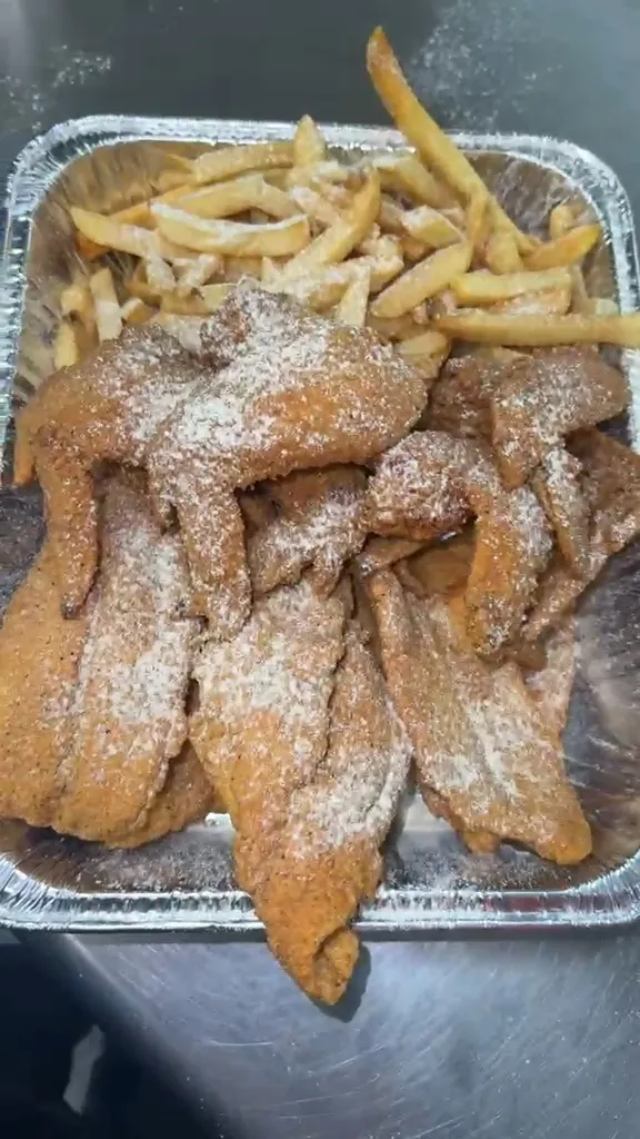 Breaded fish fillets and seasoned whole wings alongside fries in a foil catering tray