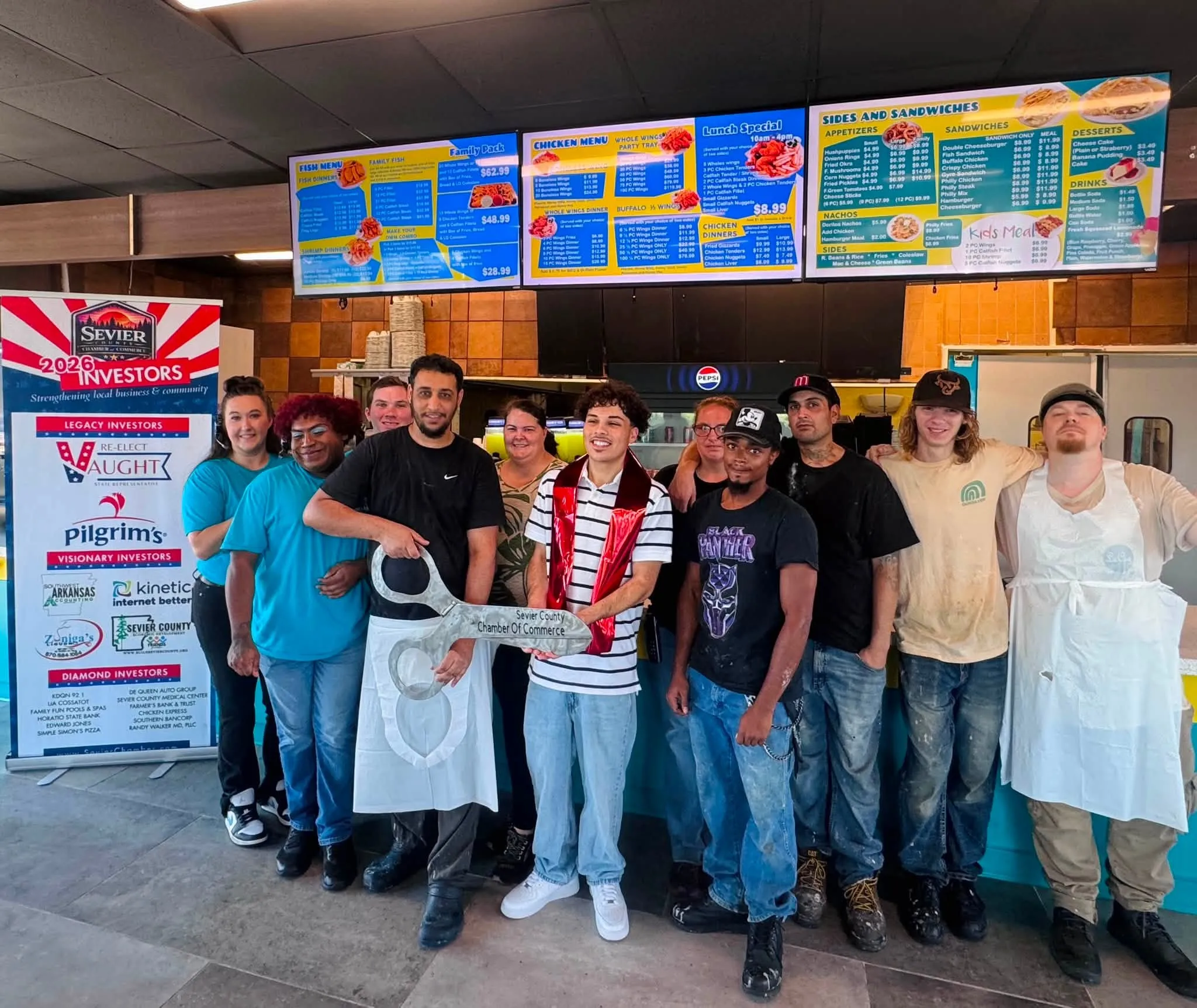 The Sharks De Queen crew standing together in the kitchen doorway on opening day